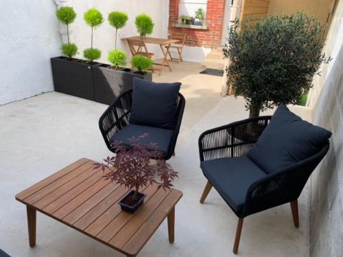 eine Terrasse mit 2 Stühlen und einem Couchtisch in der Unterkunft Maison cosy au coeur du vignoble d'Hautvillers in Hautvillers