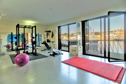 a fitness room with a gym with a large window at Douro Destilaria Residence by Porto City Hosts in Vila Nova de Gaia