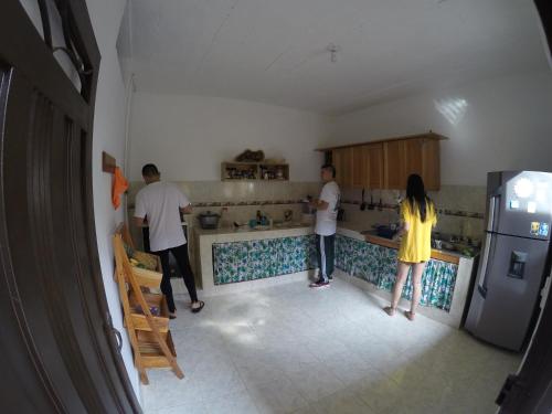 a group of people standing in a kitchen at Amagua Hostel in Caracolí