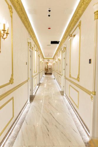 a hallway of a building with marble floors and gold trim at Royal Palace Luxury Hotel and SPA in Khmelʼnytsʼkyy