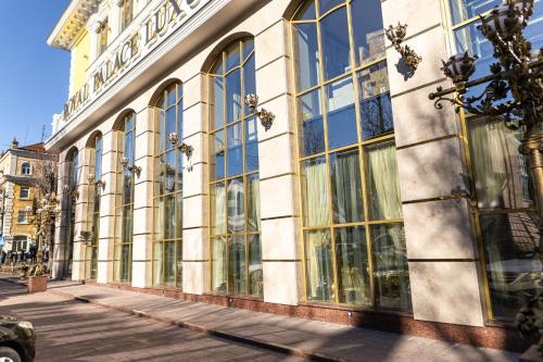 un edificio con grandes ventanas en una calle de la ciudad en Royal Palace Luxury Hotel and SPA en Khmelʼnytsʼkyy