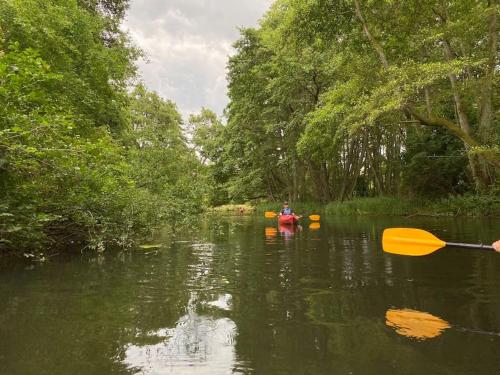 a man is kayaking in a river with a paddle at Apartament z Jaskółką piętro- duży 90 m2 plus taras in Smołdzino