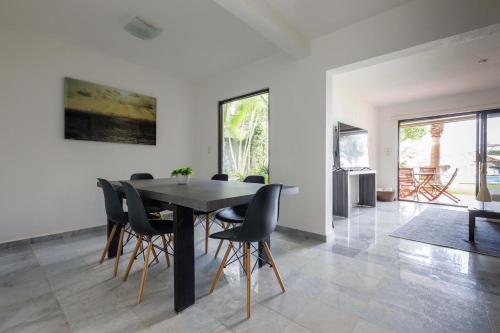 a dining room with a black table and chairs at Villas La Marina in Cancún