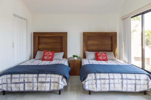 two beds sitting next to each other in a room at Villas La Marina in Cancún