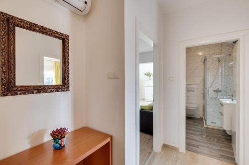 a bathroom with a mirror and a sink and a toilet at Apartments Juric in Rab