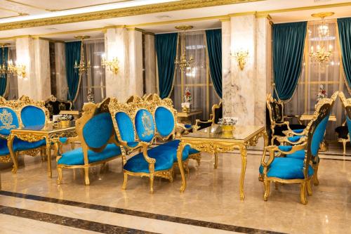 a dining room with blue chairs and a table at Royal Palace Luxury Hotel and SPA in Khmelʼnytsʼkyy