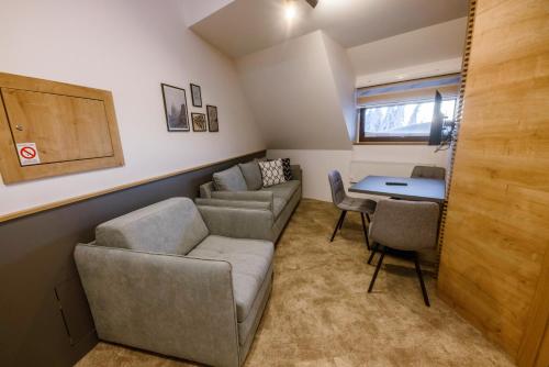 a living room with a couch and a table at Apartments Suncani Vrhovi Kopaonik in Kopaonik