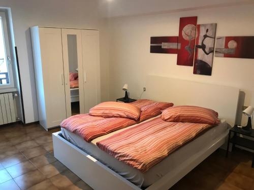 a bedroom with a bed with orange sheets on it at Appartamento Michela CIPAT 022183-AT-059221 in Darzo