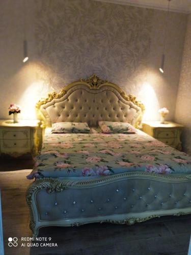 a bedroom with a large bed with a floral bedspread at Large Green Apartment in Oral