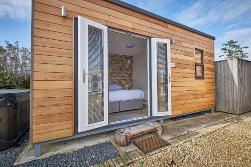 een klein huis met ramen en een bed erin bij Goldenhill Retreats in Bamburgh