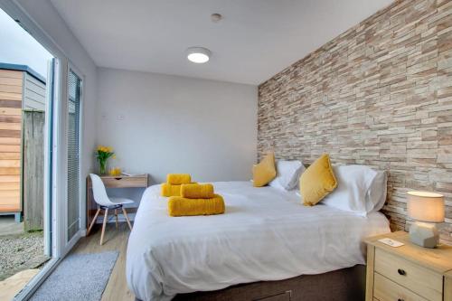 a bedroom with a large white bed with yellow pillows at Goldenhill Retreats in Bamburgh