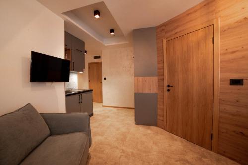 a living room with a couch and a wooden door at Apartments Suncani Vrhovi Kopaonik in Kopaonik