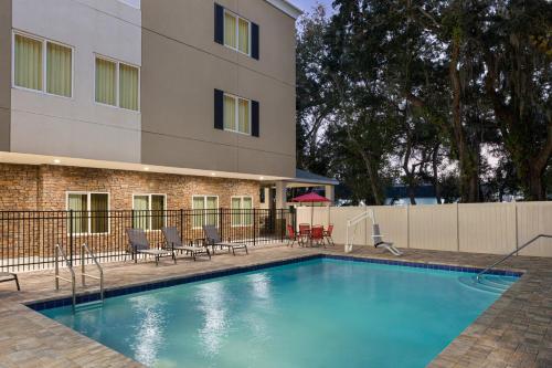 a swimming pool with chairs and a building at Candlewood Suites - Safety Harbor by IHG in Safety Harbor