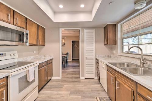 a kitchen with wooden cabinets and white appliances at Modern Port St Lucie Home with Private Outdoor Oasis in River Park