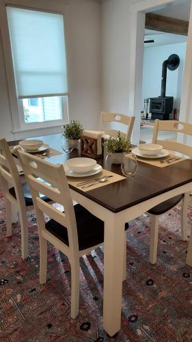 a dining room table with chairs and a table with plates at Lewisburg duplex in Lewisburg