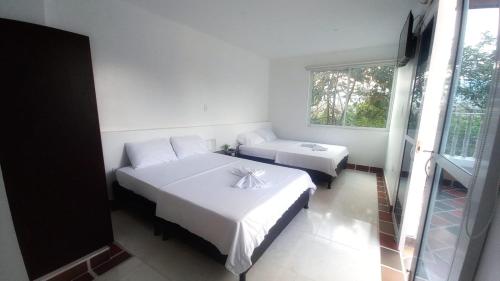 1 dormitorio con 2 camas y ventana en BONANZA, en Monterrey