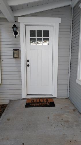 a white door with a welcome mat in front of it at Lewisburg duplex in Lewisburg