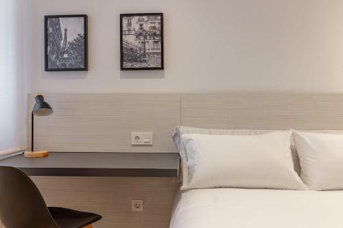 a bedroom with a bed and a desk with a chair at AH Hostel Room4You Oviedo VUT3026AS in Oviedo