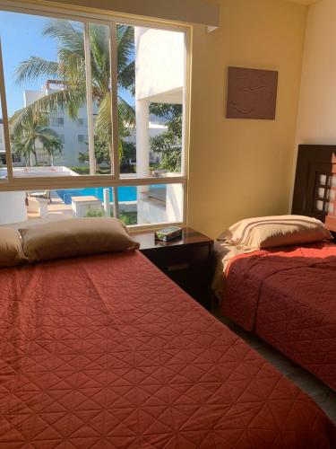 a bedroom with two beds and a large window at Villa&Roofgarden -Jacuzzi privado- Relax&Confort in Acapulco