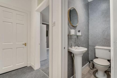 亞歷山卓的住宿－The Garden Flat, Loch Lomond，浴室配有白色卫生间和盥洗盆。