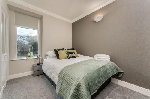 a small bedroom with a bed and a window at The Garden Flat, Loch Lomond in Alexandria