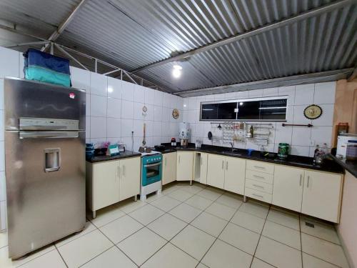 a large kitchen with a stainless steel refrigerator at Casa Localizado no Centro de Guape MG in Guapé
