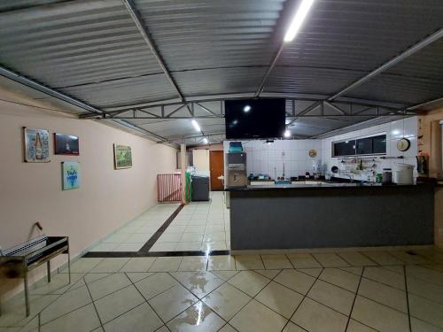 a large room with a kitchen and a tv at Casa Localizado no Centro de Guape MG in Guapé