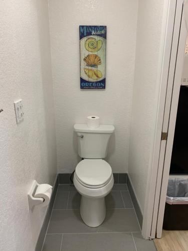 a bathroom with a toilet with a picture on the wall at San Dune Inn in Manzanita