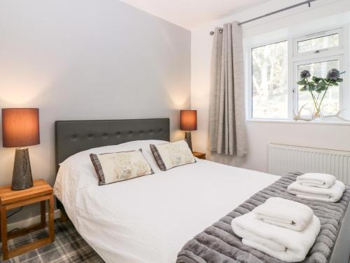 une chambre avec un lit avec des serviettes dessus dans l'établissement White Hillocks Cottage, à Inchmill