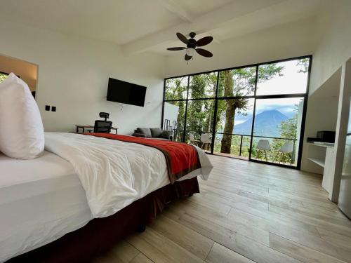 a bedroom with a large bed and a large window at Sangregado Lodge in Fortuna