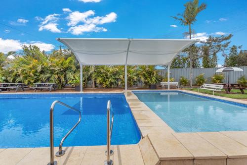 a swimming pool with a white canopy over it at Lifestyle Villages Redhead in Redhead