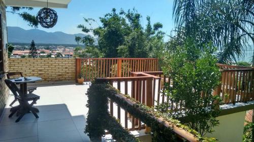 d'un balcon avec une clôture en bois et une table. dans l'établissement Pousada Vista da Barra, à Florianópolis