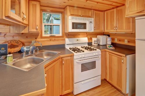 a kitchen with a white stove top oven next to a sink at Racoon Retreat in Eastsound