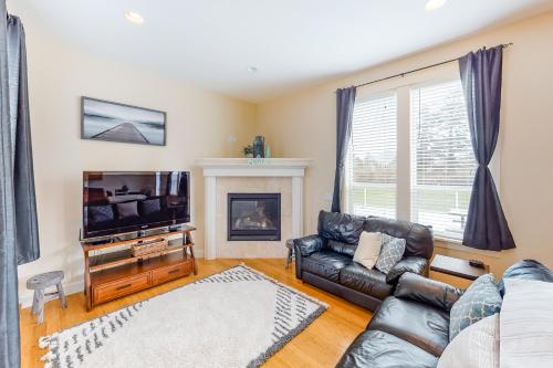 a living room with a couch and a tv and a fireplace at Fairway and Far Away in Seaside