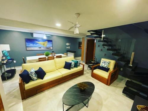 sala de estar con sofá y escalera en RESIDENCIAL MONTE DAS OLIVEIRAS - Arraial D'Ajuda - Porto Seg - Ba - Alto da Pitinga - Casa Premium - Casa Buriti en Porto Seguro
