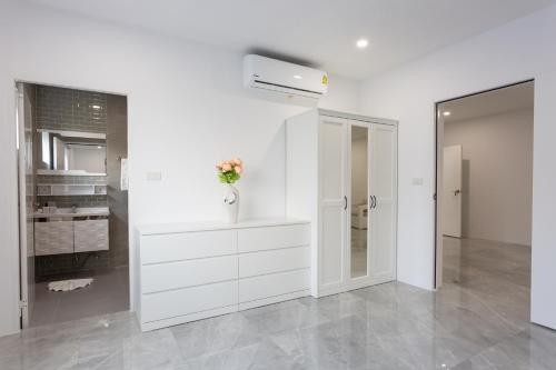 a white kitchen with a vase with flowers in it at Michael villa in Koh Samui