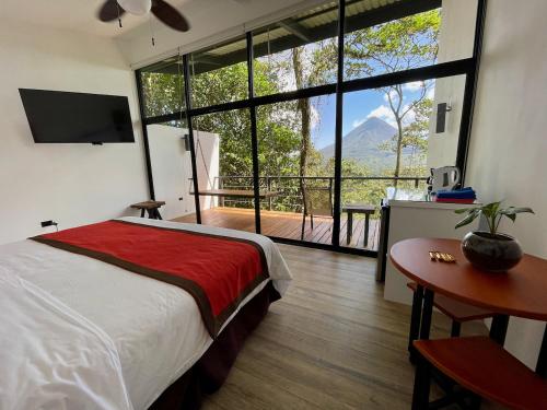 a bedroom with a bed and a large window at Sangregado Lodge in Fortuna