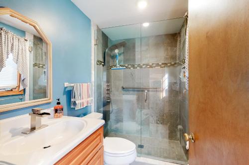 uma casa de banho com um chuveiro, um WC e um lavatório. em Wooded Oasis em Edgartown