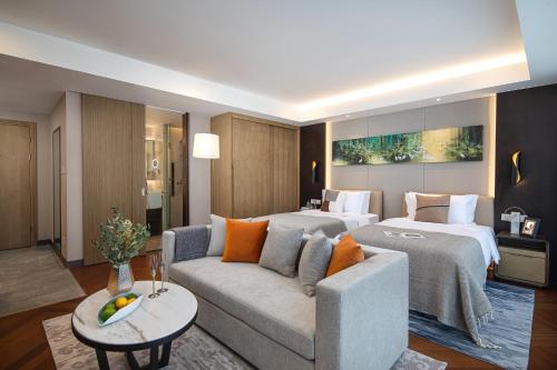 Habitación de hotel con 2 camas y sofá en Ascott New District Wuxi en Wuxi