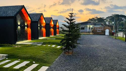 a christmas tree in front of a row of houses at ก๋างโต้ง คอฟฟี่รีสอร์ท in Ban Na Kham