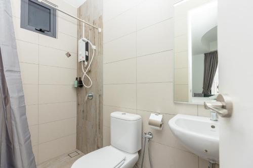 a white bathroom with a toilet and a sink at ArteS Suite Penang, by HOMEY in George Town