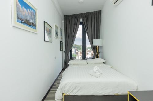 two beds in a hotel room with a window at ArteS Suite Penang, by HOMEY in George Town