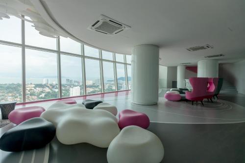 a room with pink and white chairs and windows at ArteS Suite Penang, by HOMEY in George Town