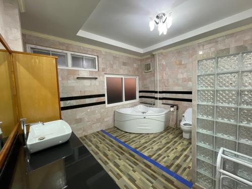 La salle de bains est pourvue d'une baignoire, d'un lavabo et de toilettes. dans l'établissement minimal house phichit, à Phichit