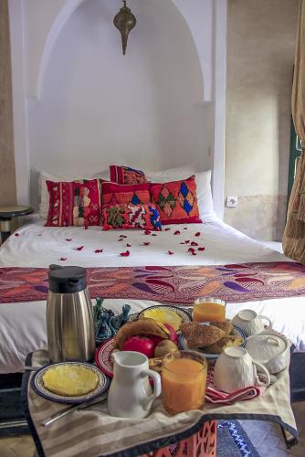 a tray of food on a table in front of a bed at Riad Dar Habiba by Garden Wonders in Marrakech