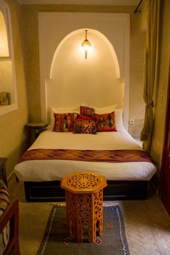 a bedroom with a large bed with an arched window at Riad Dar Habiba by Garden Wonders in Marrakech