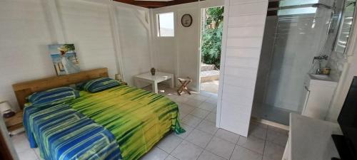 een slaapkamer met een bed en een inloopdouche bij Gite Mamour - Charmant petit bungalow à découvrir in Baillif