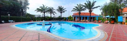 a swimming pool in a resort with palm trees at Đồi Dương Hotel in Phan Thiet