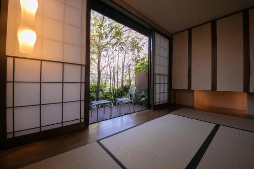 an empty room with a large window and a rug at Yufuin Bettei Itsuki in Yufuin