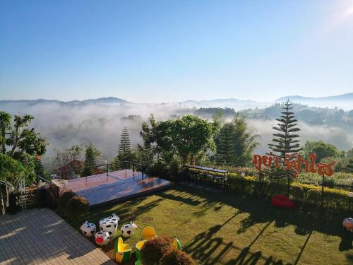 a garden with a view of a foggy hillside with a view at Phuyafahsai The Resort Khao Kho in Khao Kho